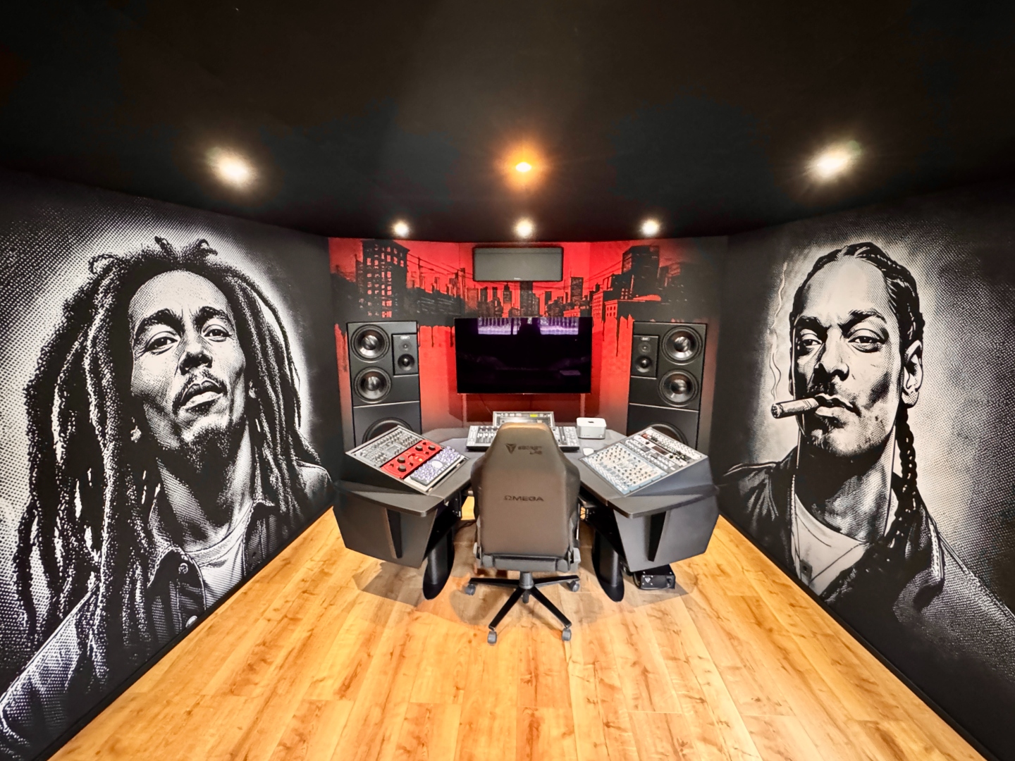 The real MMA Studios control room in Bochum: large-format graphic-novel-inspired artwork on acoustically transparent fabric, a red city-skyline glow behind the monitors, an Argosy workstation and analog gear on a warm wood floor.